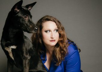 Black dog and woman in blue shirt looking to one side. Image for the production 'Bitch' as part of Brisbane Festival 2017