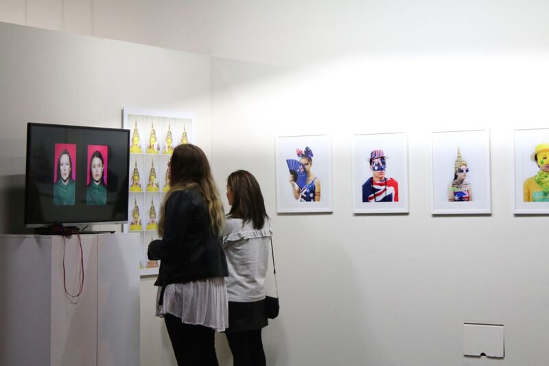 Viewers admiring art at Cause & Effect. Image credit: Carnival of the Bold.