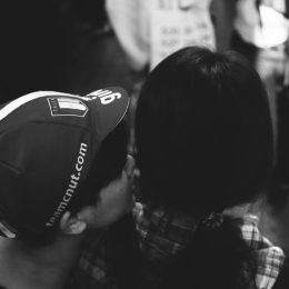 Two people's heads close to each other as if whispering.